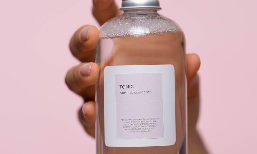 Person Holding a Glass Bottle With Tonic .pexels