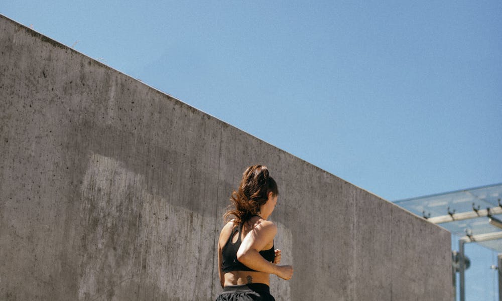 Woman in Black Tank Top and Black Shorts Running .pexels