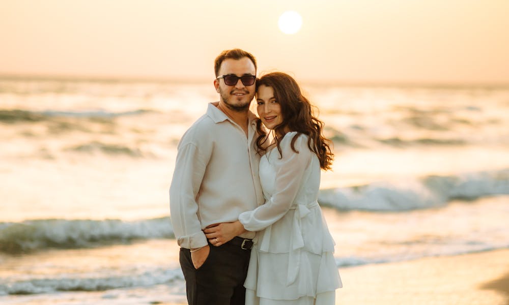 A couple standing on the beach at sunset .pexels