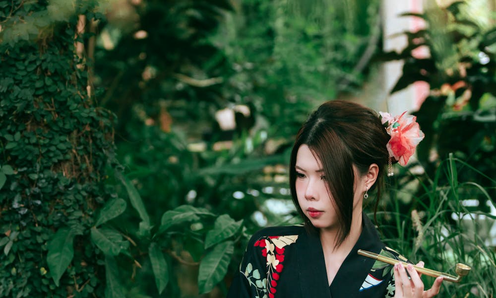 A woman in a kimono sitting in a garden .pexels
