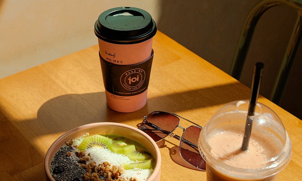 A table with a cup of coffee and a bowl of food .pexels