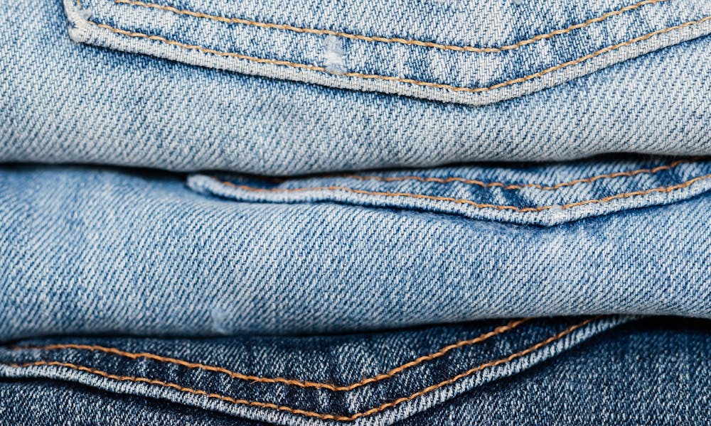 Stack of blue jeans arranged by color .pexels