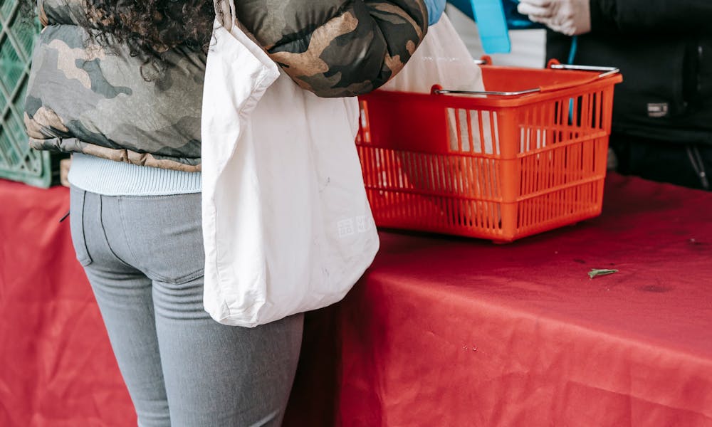 Unrecognizable woman in protective gloves buying goods on market .pexels