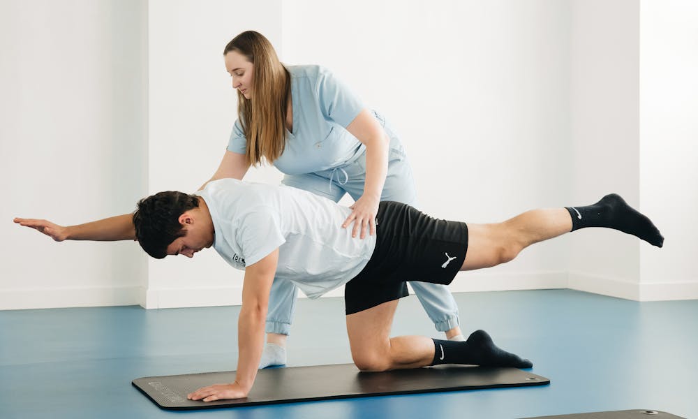 A man doing a plank exercise with a woman .pexels