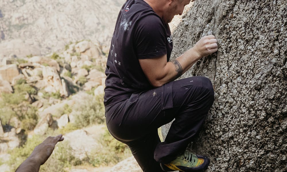 A man climbing on a rock with other people .pexels
