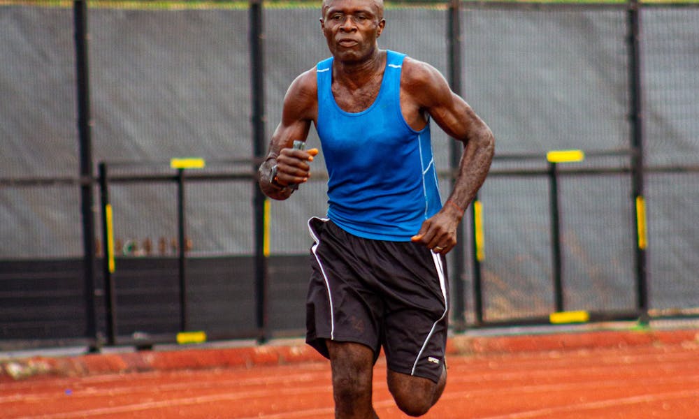 A man running on a track in a blue shirt .pexels