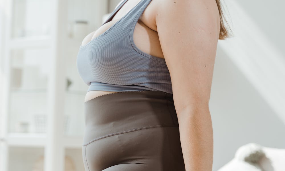 A Woman in Brown Leggings Holding a Dumbbell .pexels