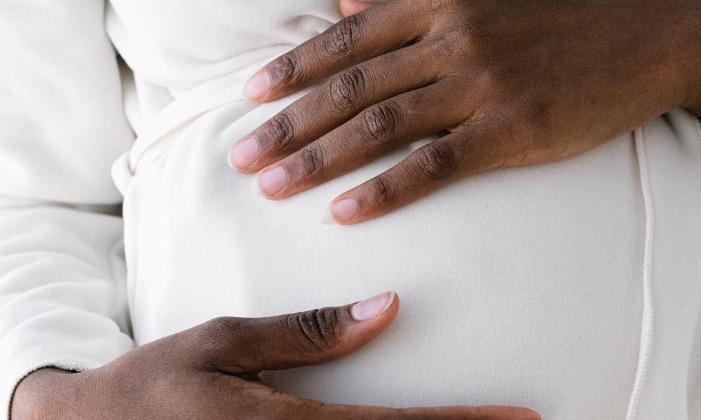Crop pregnant black woman touching belly .pexels