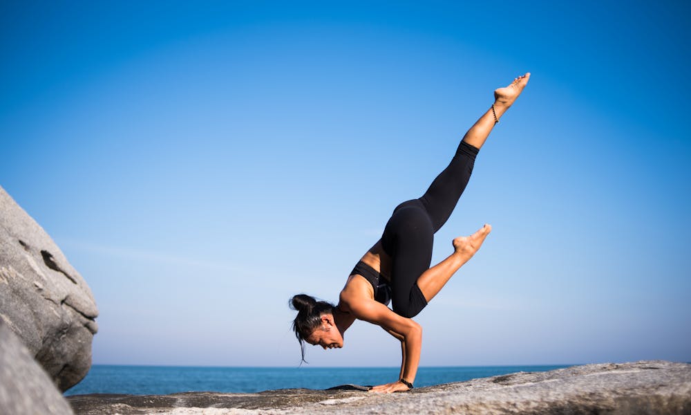 Low Angle View of Woman Relaxing on Beach Against Blue Sky .pexels