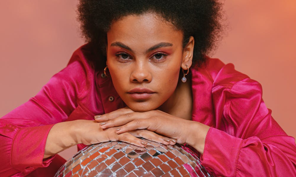 A Woman Posing while Holding a Disco Ball .pexels