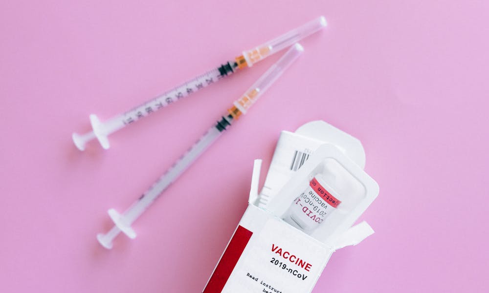 Preparing Covid Vaccine on Pink Surface .pexels