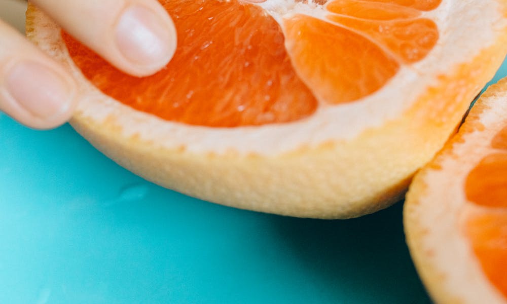 Person Touching Sliced Orange Fruit .pexels