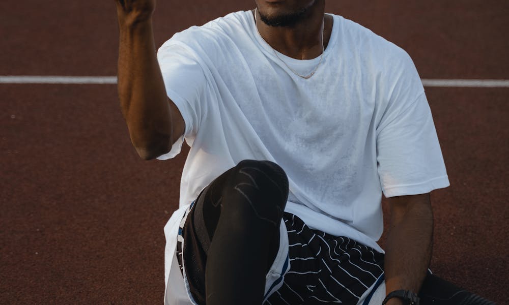 Man in White Crew Neck T-shirt Doing Trick with Basketball  .pexels
