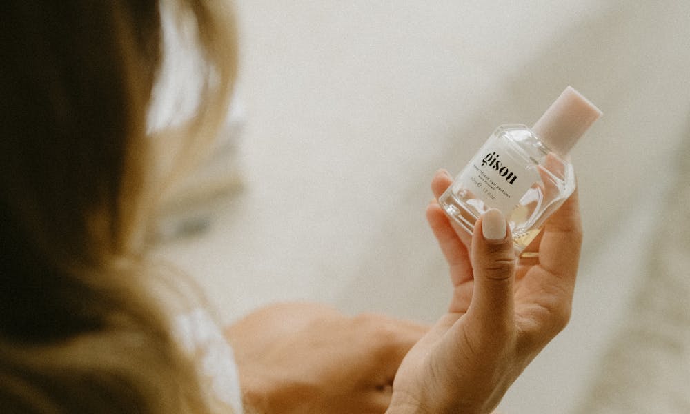 Close-up of Woman Holding a Cosmetic Product in a Glass Container .pexels