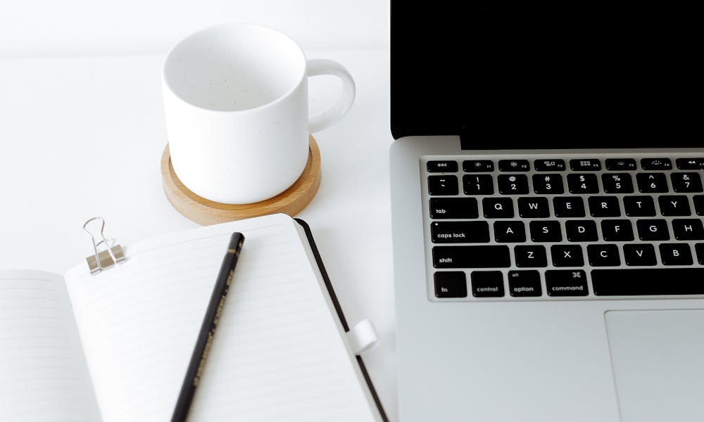 Workplace with laptop and opened diary .pexels