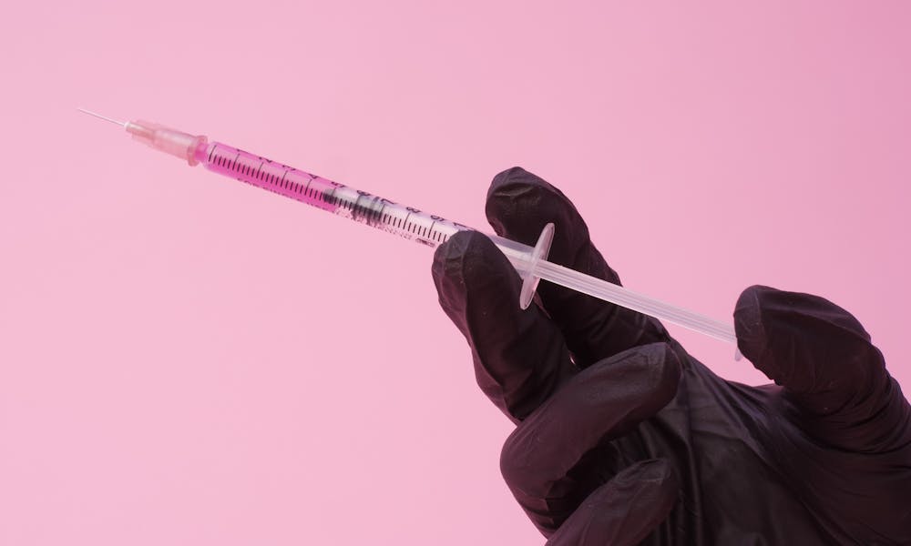 Anonymous doctor showing syringe with injection .pexels