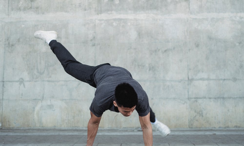 Unrecognizable strong sportsman performing break dance near wall .pexels