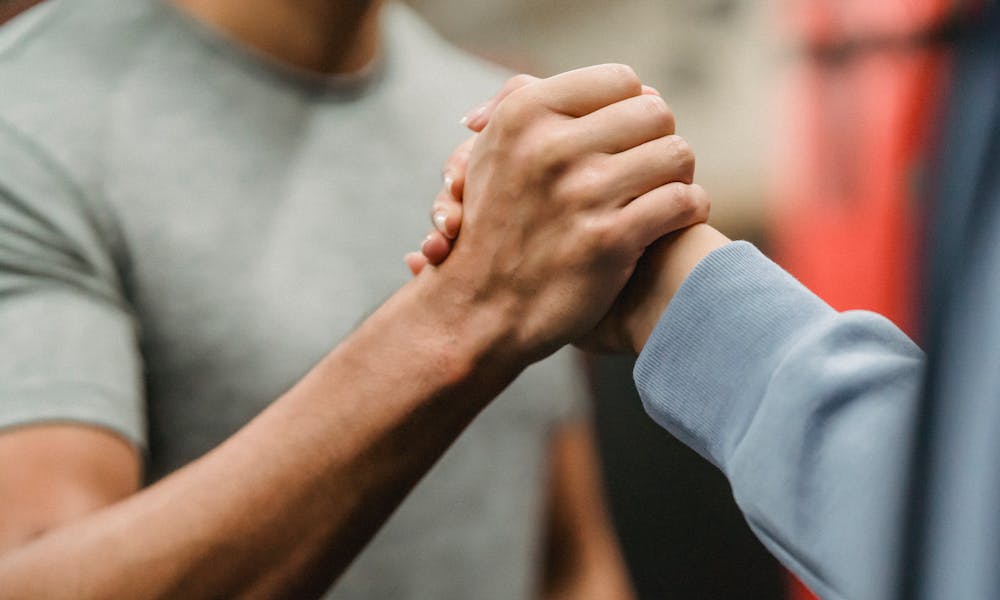 Crop sportive couple clasping hands in gym .pexels