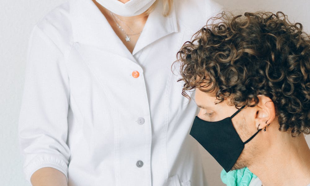 Woman in White Button Up Shirt Kissing Woman in Green Shirt .pexels