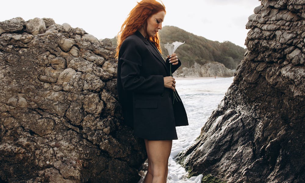 A woman standing on rocks in the ocean .pexels