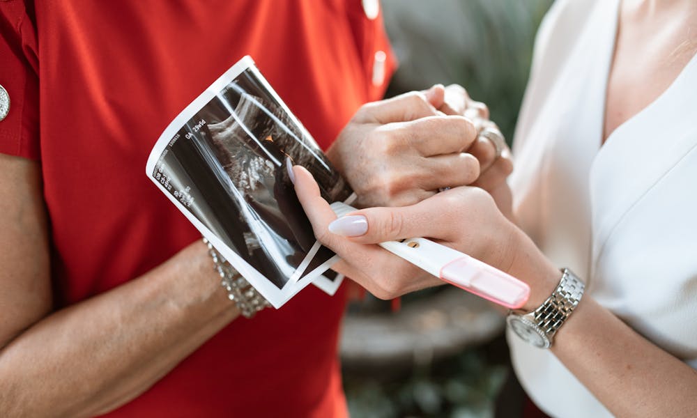 Person in Red Shirt Holding White Tablet Computer .pexels