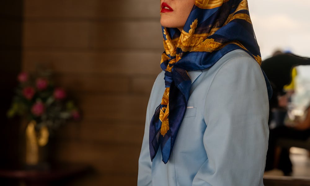 A woman wearing a blue jacket and scarf .pexels