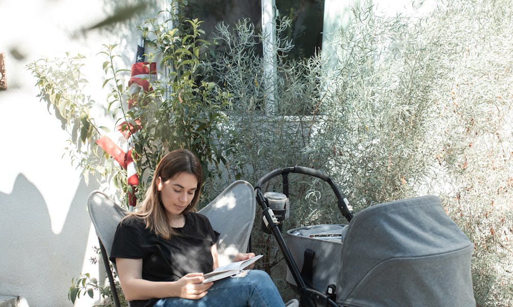 Woman in Black Jacket and Blue Denim Jeans Sitting on Black and White Chair .pexels