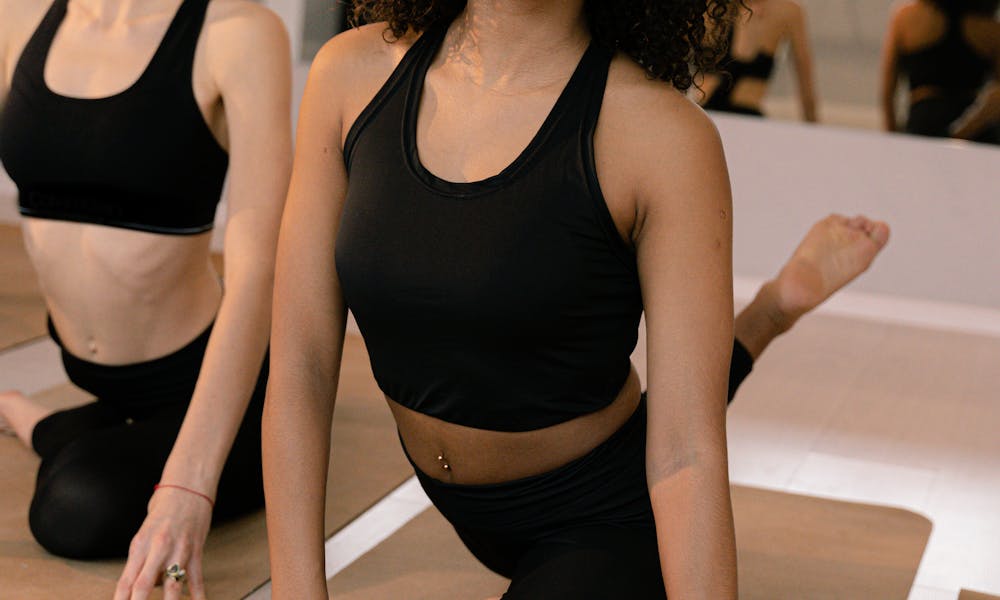 Woman in Black Tank Top and Black Leggings Doing Yoga .pexels