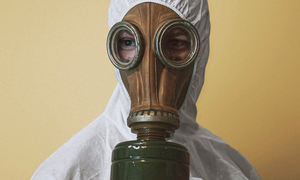 Person Wearing Gas Mask and White Protective Suit .pexels