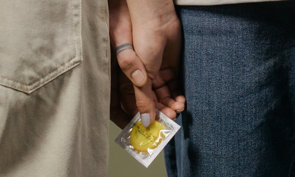 Couple Holding Hands and a Condom  .pexels