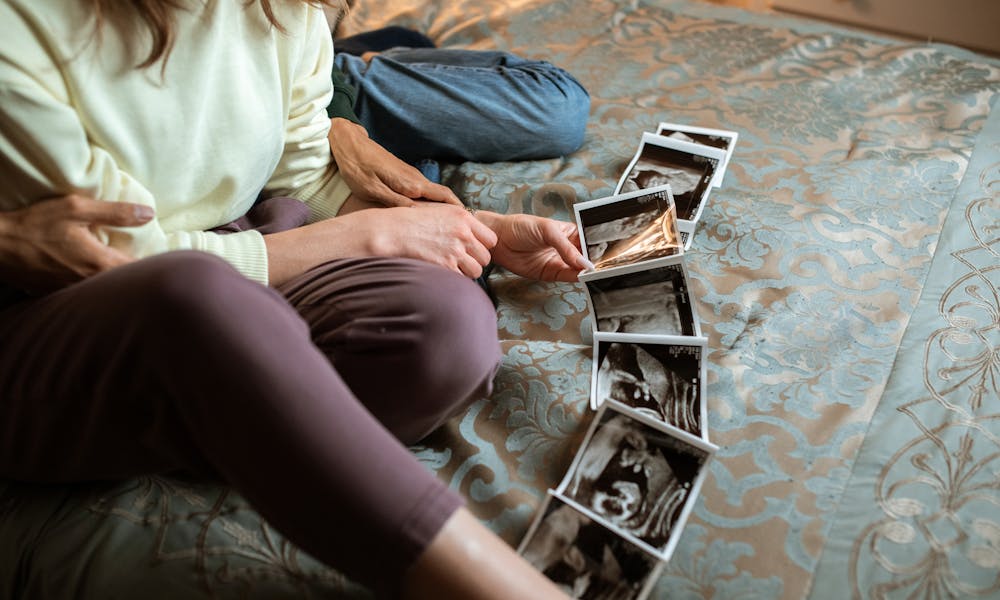 Person in White Shirt and Blue Pants Sitting on Blue and White Floral Area Rug .pexels