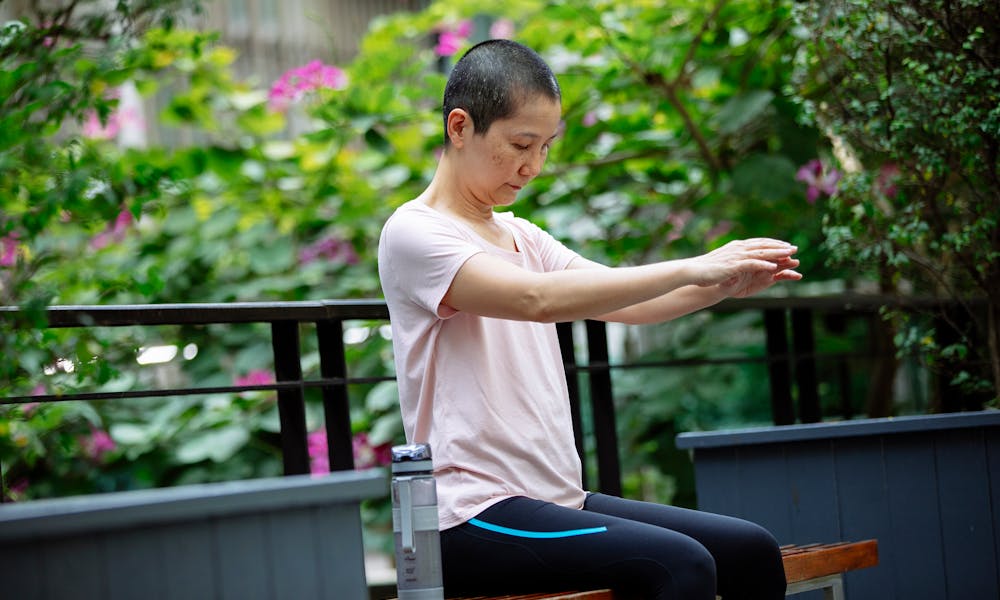 Asian woman suffering from cancer doing exercises in park .pexels