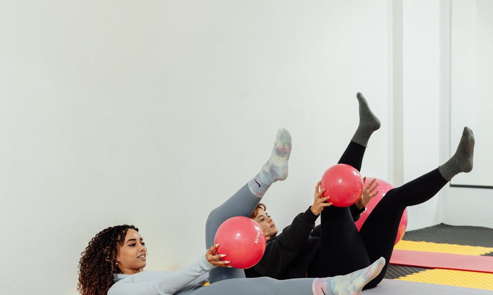 Women Exercising with Pink Balls at Gym .pexels
