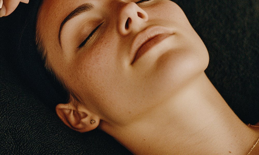 a professional therapist gently adding cream on a woman's face .pexels