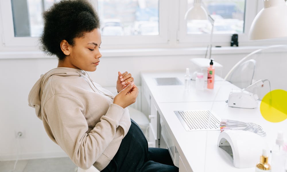 Pregnant Woman in Beige Hoodie Sitting  .pexels