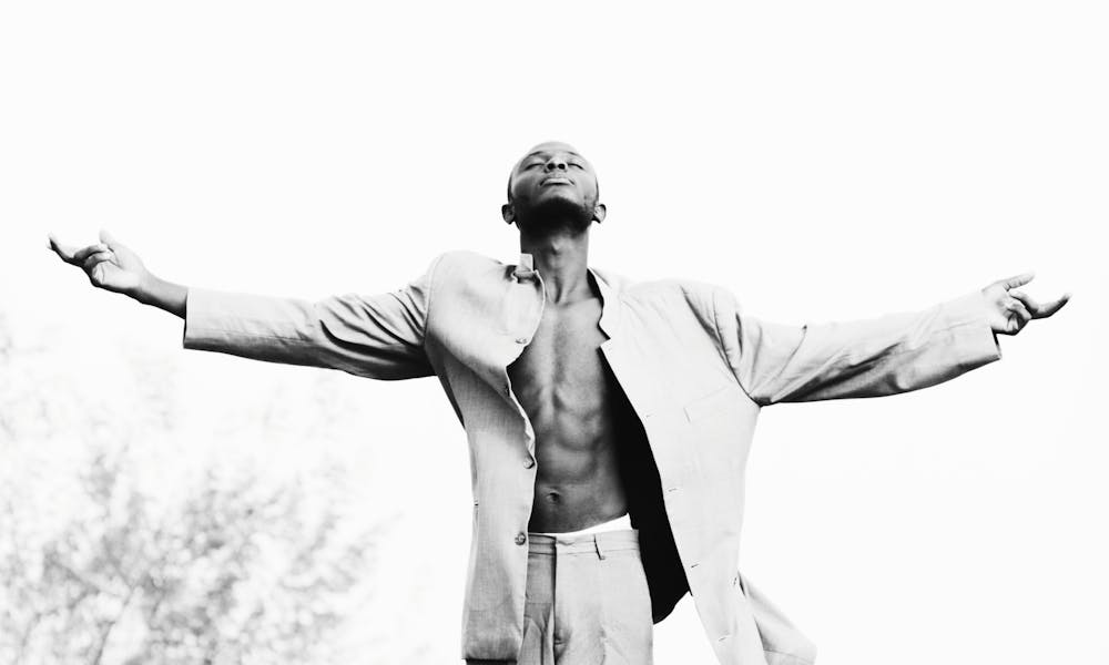 Man Standing with Arms Open Looking up Towards sky .pexels