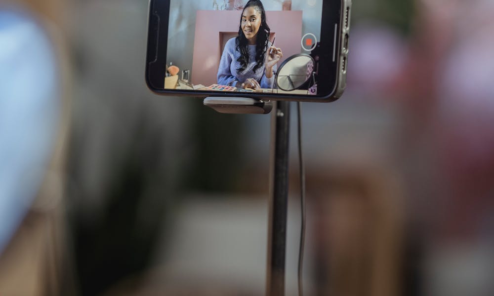 Black female filming beauty blog on smartphone .pexels