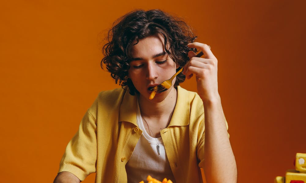 A Young Man Eating French Fries .pexels