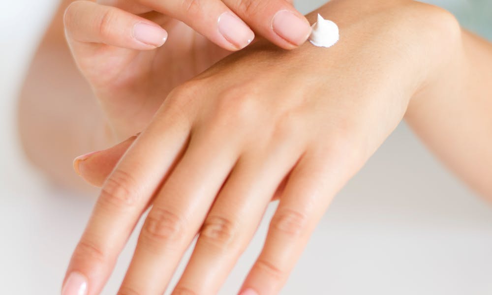 Woman Applying Lotion on Hand .pexels