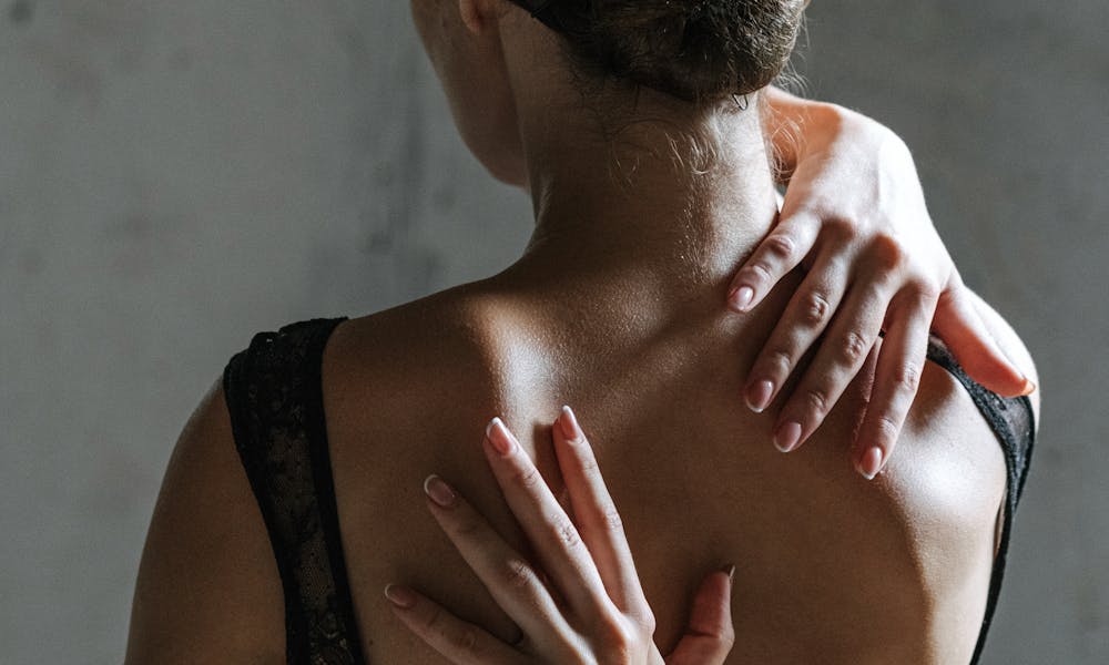 Woman in Black Tank Top With Hands on her Back  .pexels
