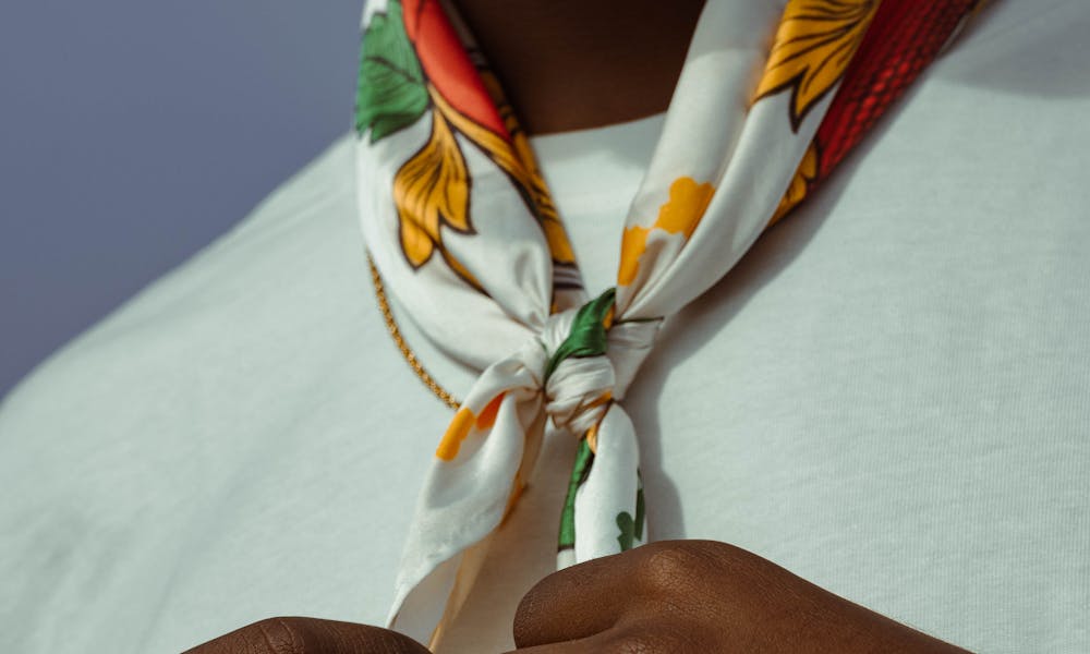 Close-up of a person adjusting a floral necktie, showcasing modern fashion style. .pexels