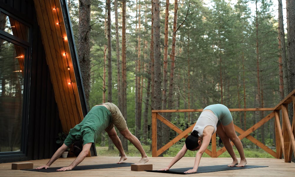 Couple doing Yoga on Cabin Patio .pexels