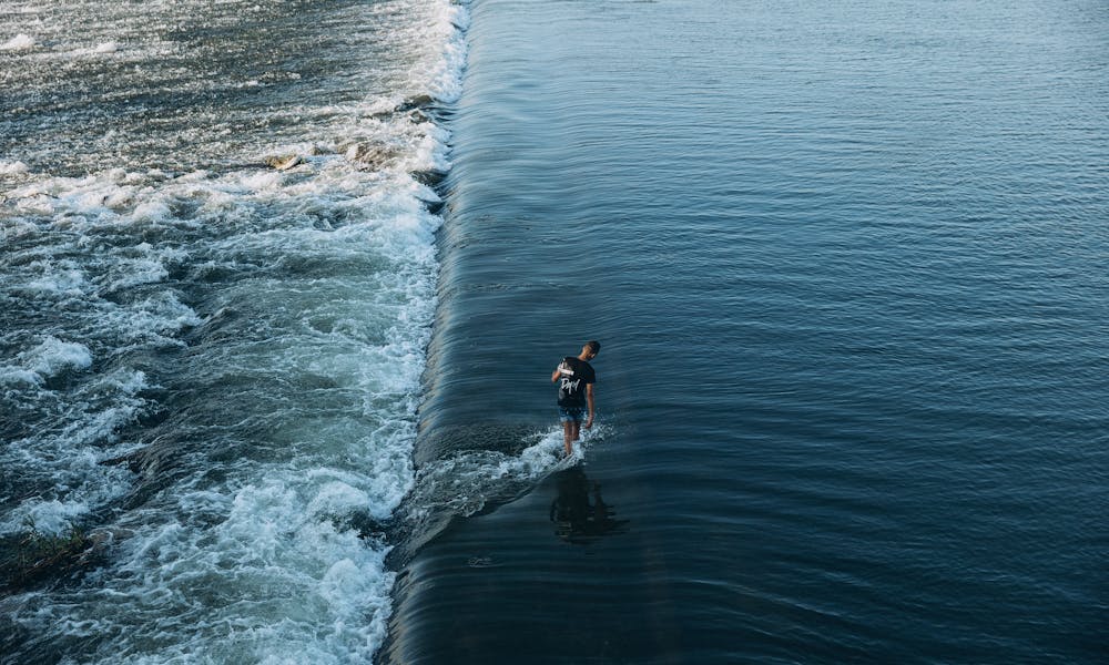 A person walking boldly on a river's surface, capturing a serene scene near Al Qanatir Al Khayriyyah, Egypt. .pexels