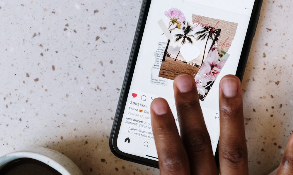 Close-up of hand scrolling Instagram on smartphone near coffee cup on table. .pexels