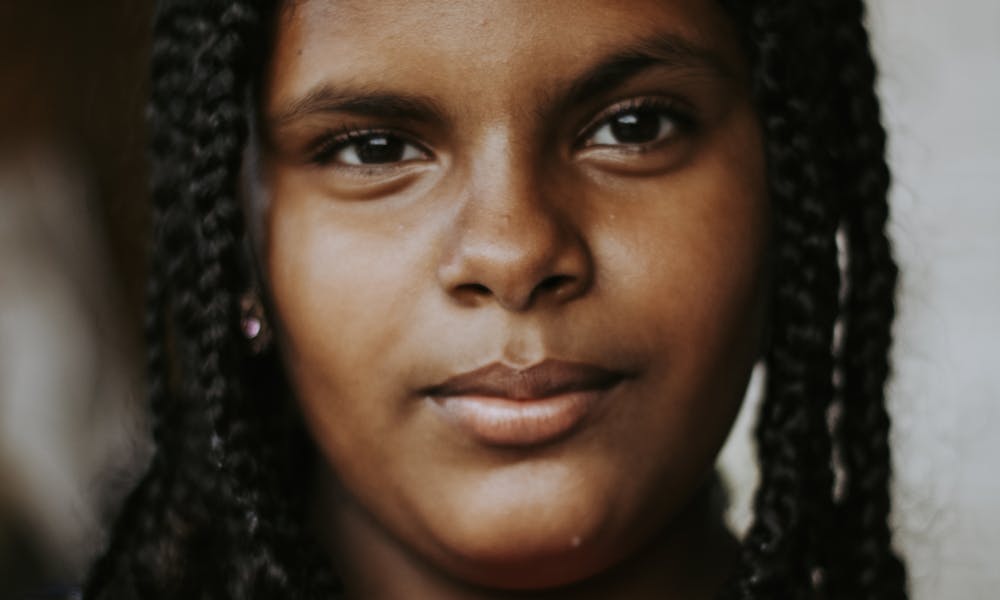 Close-up portrait of a teenage girl with braided hair, showcasing natural beauty. .pexels