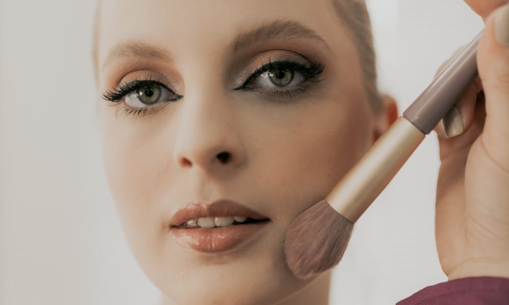 Elegant close-up of woman getting makeup done, highlighting flawless skin and beauty. .pexels