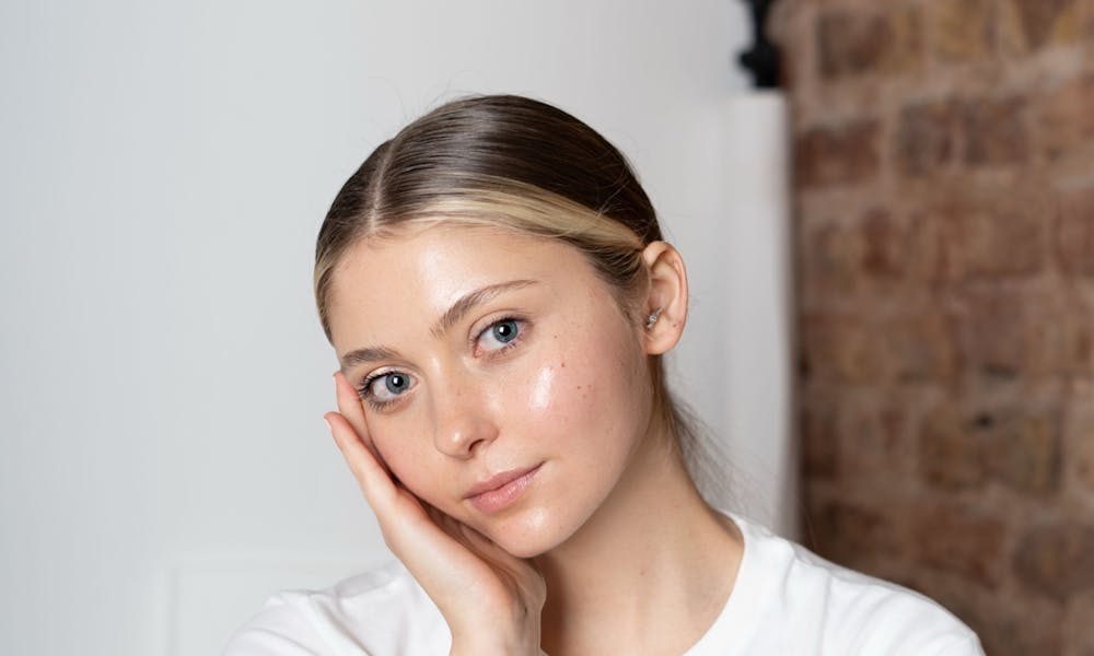 Portrait of a young woman with a thoughtful pose in a minimalist setting. .pexels