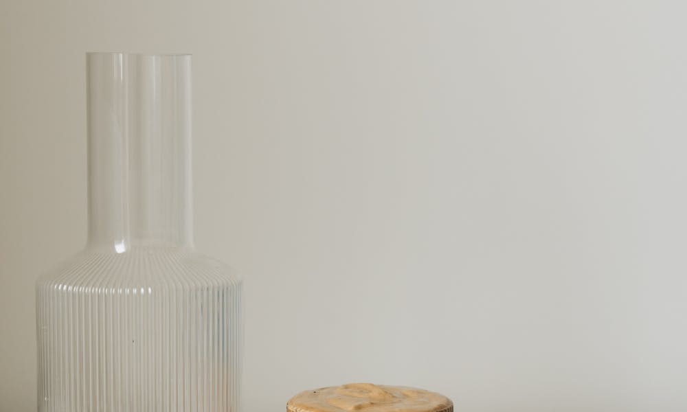 Elegant minimalist setup featuring a hand holding dalgona coffee in a ribbed glass on a neutral background. .pexels