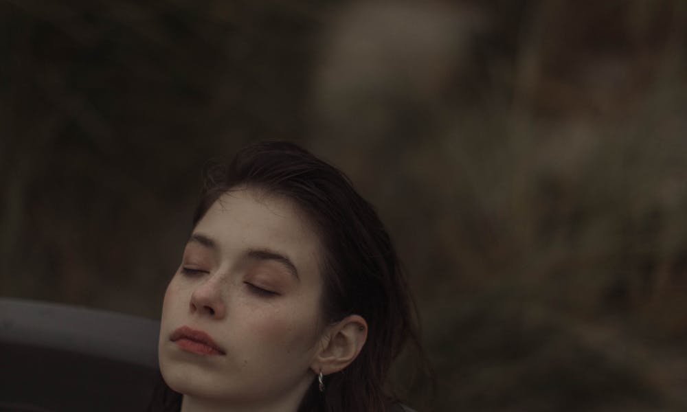 A serene portrait of a woman enjoying a relaxing moment in an outdoor hot tub at dusk. .pexels