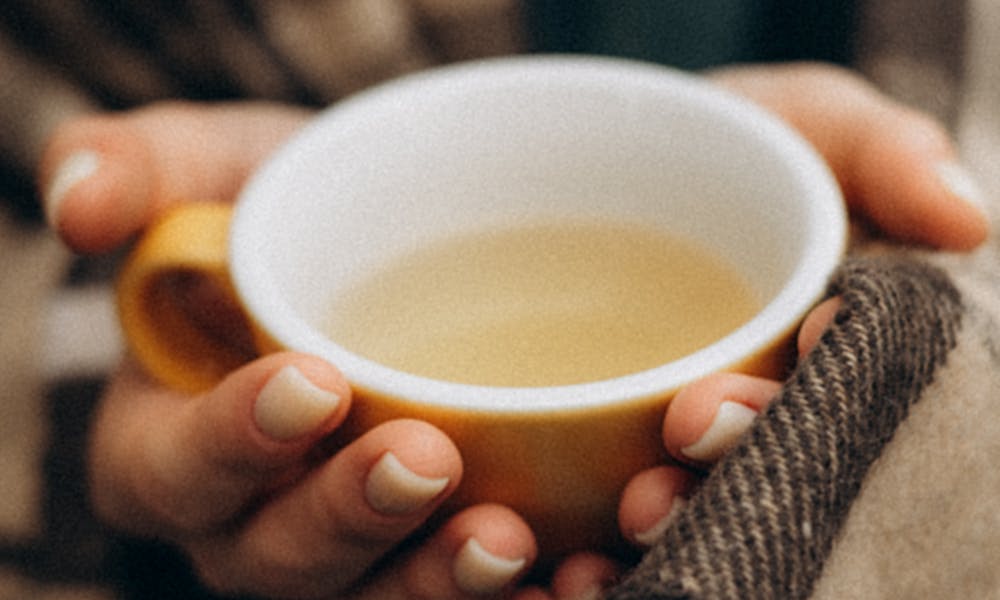 Hands wrapped in a blanket holding a warm cup of tea, evoking coziness and comfort. .pexels